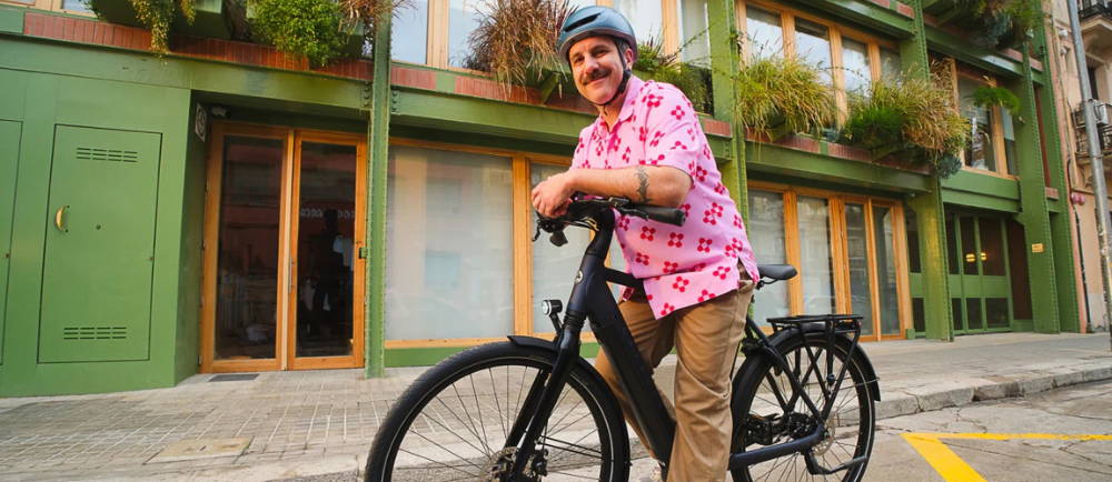 Man leaning over electric bike on street