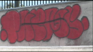 removing red graffiti from concrete wall