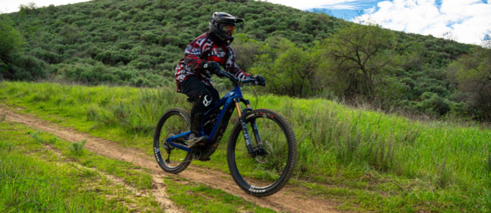 a man riding a blue full suspension electric mountain bike in the LA hills