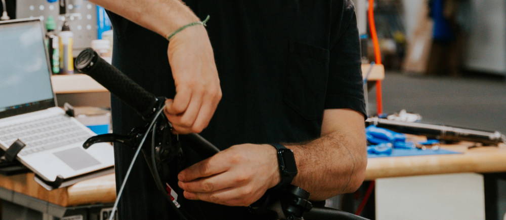 a man in the shop working on an elctric bike