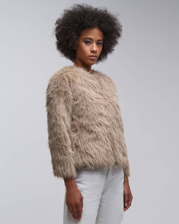 Model wearing a beige faux fur sweater with white pants