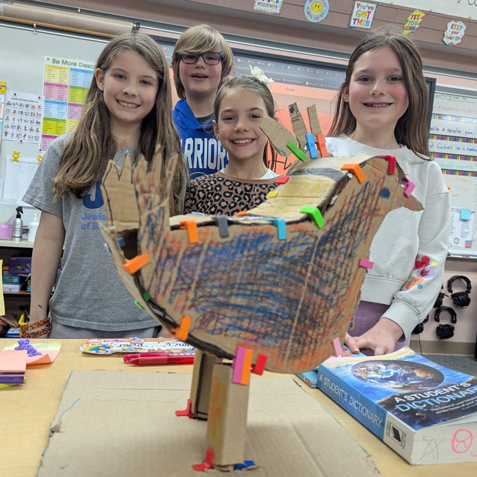 students cardboard templates held up