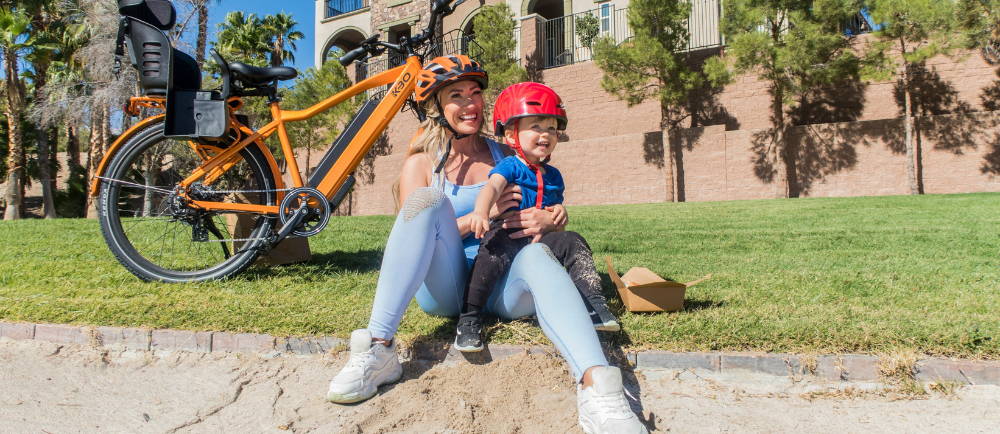 Mom and child with KBO electric bike on grass