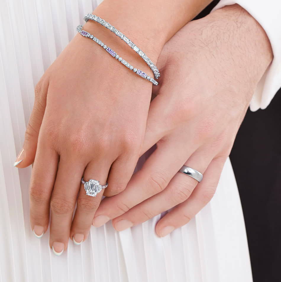 Bride wearing Ashoka diamond ring holding grooms hand. 