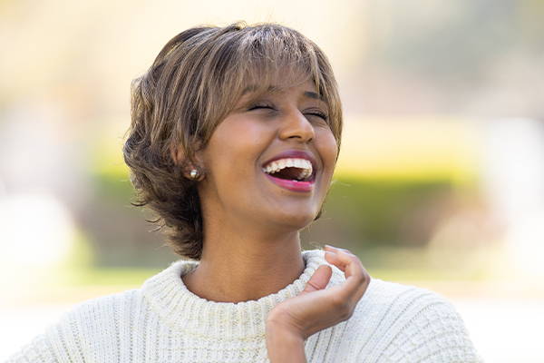 Woman laughing while wearing a short wig.