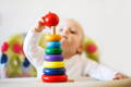 Toddler playing with a Montessori stacking toy. 