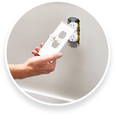 Person holding outlet light cover with backside of cover in view