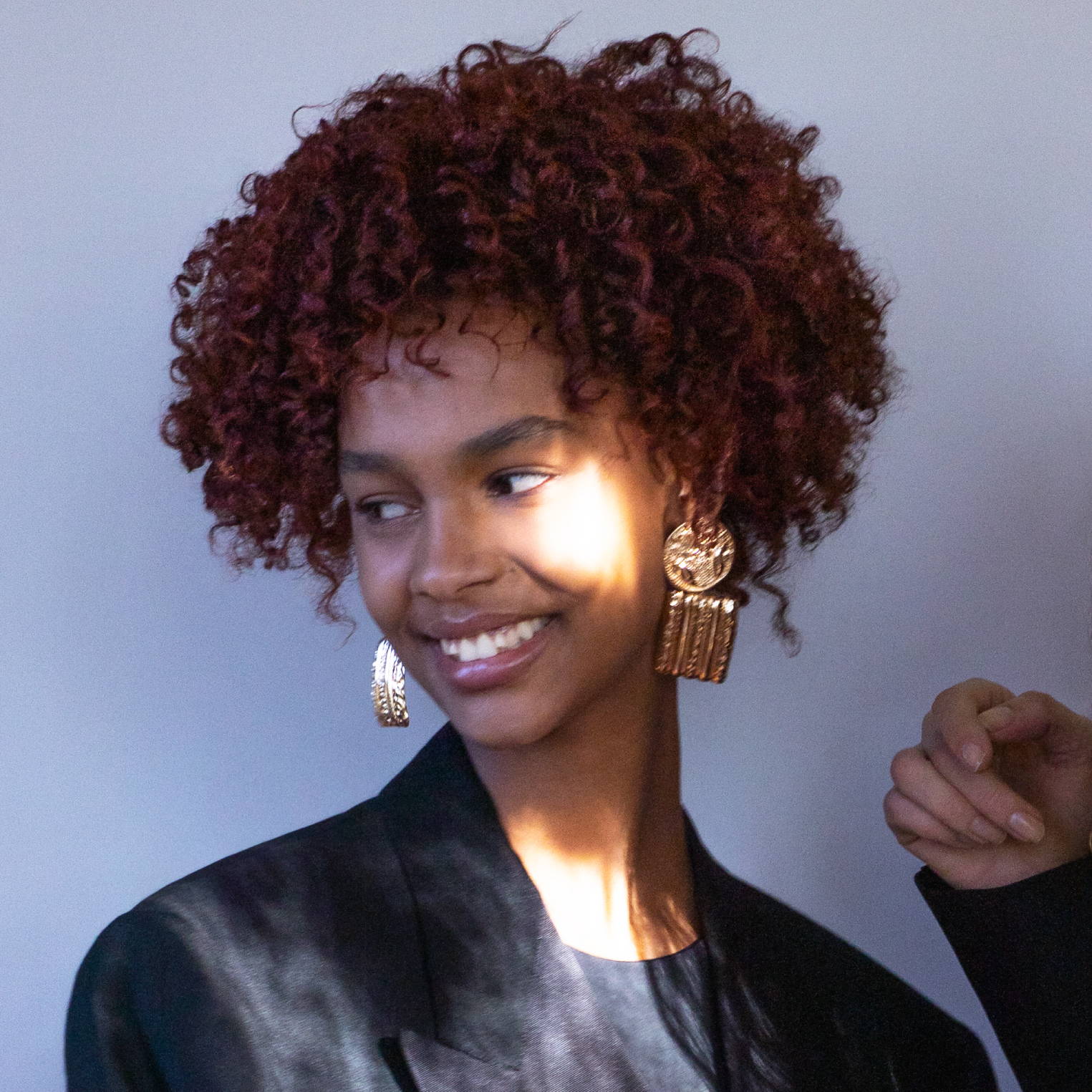 Smiling Davines model with short, curly brown hair