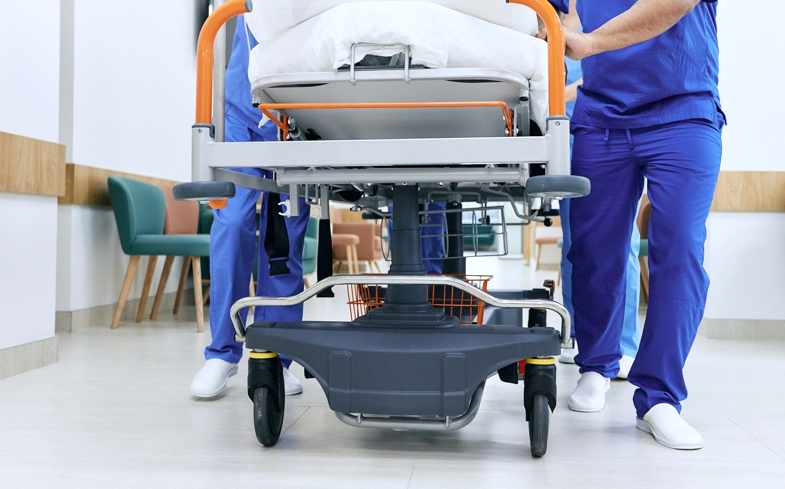 Medical staff pushing patient on medical gurney at emergency department, bottom view. Hospital emergency and healthcare workers