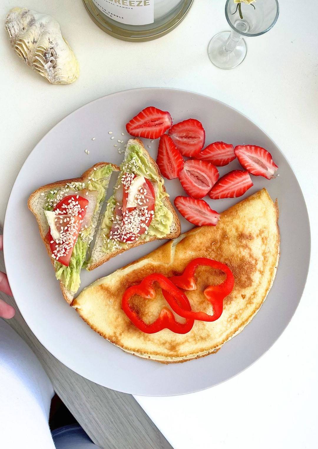 plate of healthy foods, avacado toast, savory crepe and strawberries
