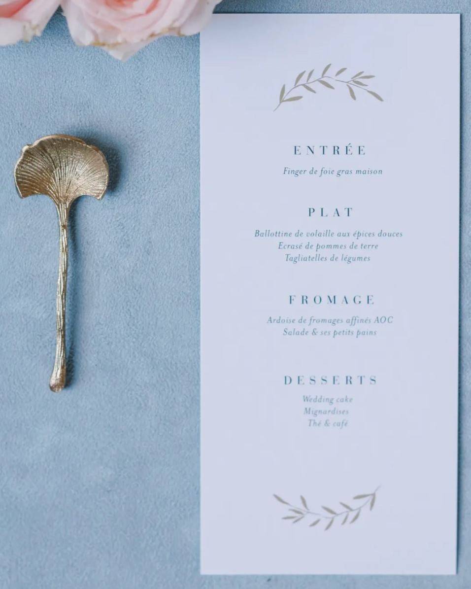 Menu élégamment présenté pour un mariage, décrivant les plats exquis accompagnés des vins sélectionnés avec soin pour chaque service.