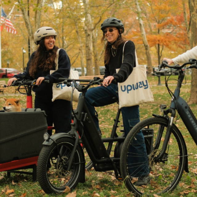 women on electric bikes in a park