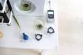 A whisking cup sits on the Matcha Maker platform with another whisking cup and a digital sensor nearby.