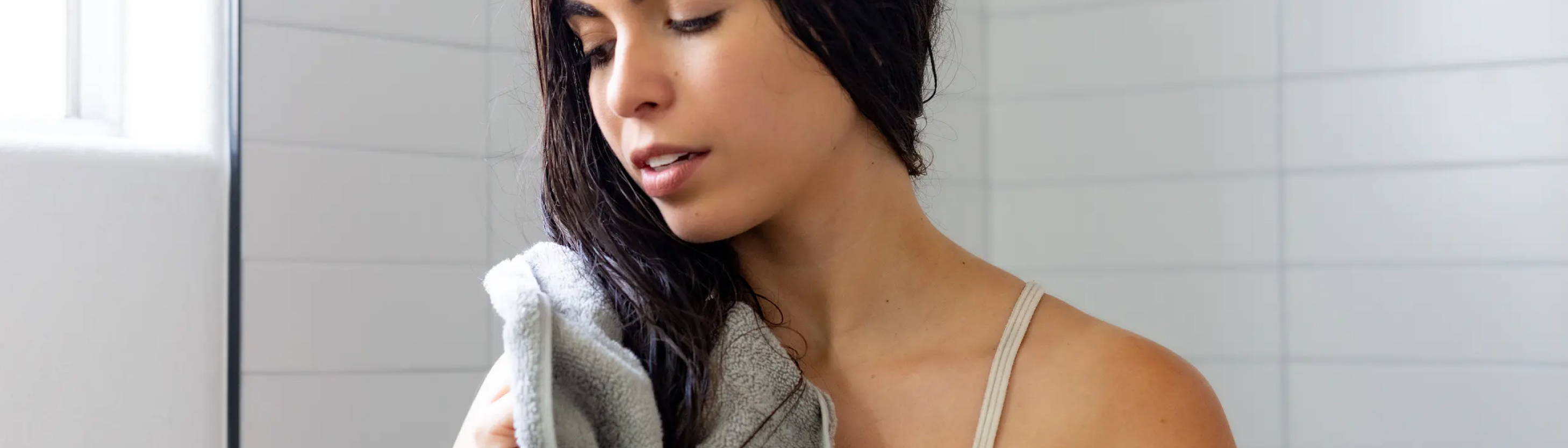 woman towel-drying her damp hair