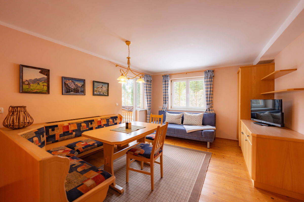 Essbereich mit Holztisch und Sofa im Apartment am Wilden Bächle in Mittelberg.