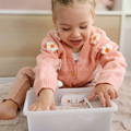 Little girl happily playing with the Montessori ABC Matching Cards. 