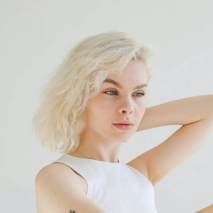 woman with platinum blond curls in a blunt bob
