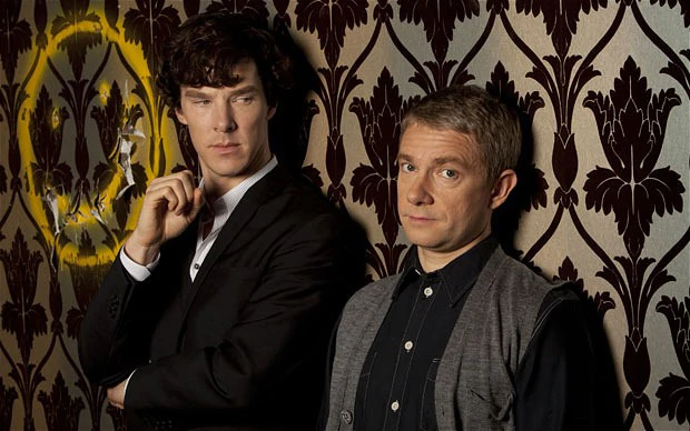 Sherlock looking over at Watson who is raising his eyebrow at the camera.