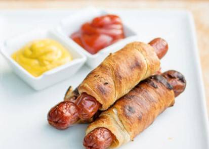 Hot dogs wrapped in crescent rolls with condiments