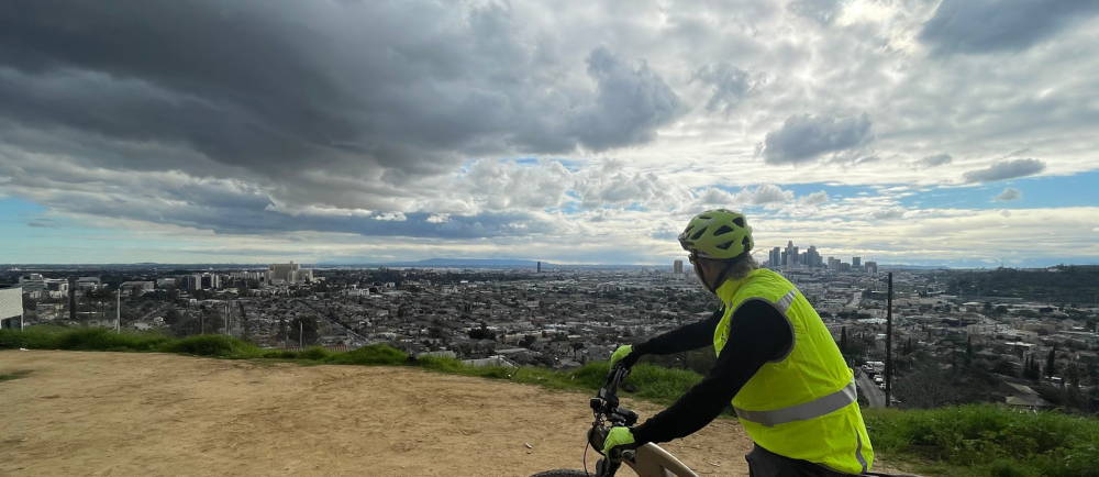 a man riding an Aventon Aventure electric bike over los angeles