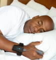 Man sleeping with Checkme O2 Max wrist oxygen monitor and ring sensor for overnight sleep tracking