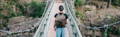 Man wearing an Isle Royale pack standing on a walking bridge over a river