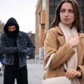 male stalker in hoodie following his target female victim male stalker in hoodie following his target female victim