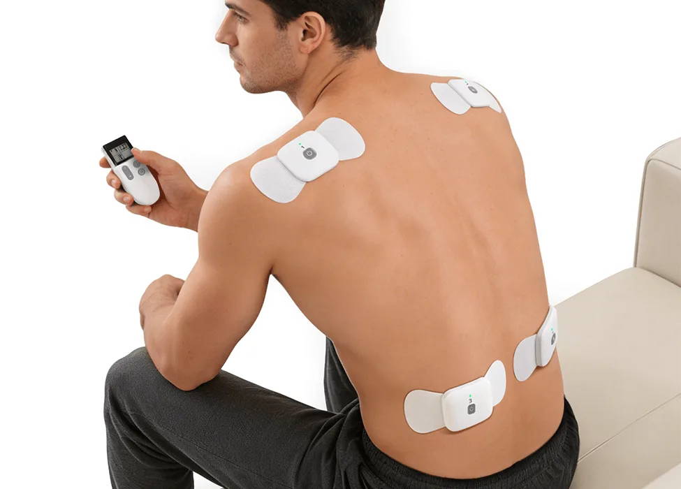 男性が、背中の上部と下部にワイヤレスポッドを装着したWellueケーブルフリーTENS療法デバイスを使用している。