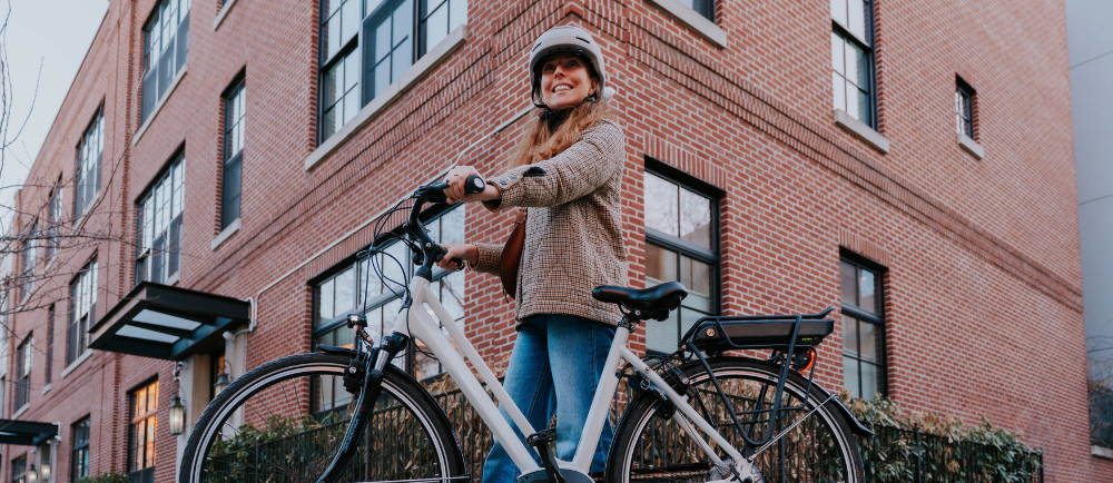 A woman standing next to a white Gazelle Medeo electric city bike