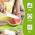 Little girl cutting a piece of watermelon with her Montessori Cooking Set knife. 