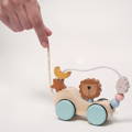 Woman's hand interacting with the wooden Montessori Roaring Roller pulling toy.