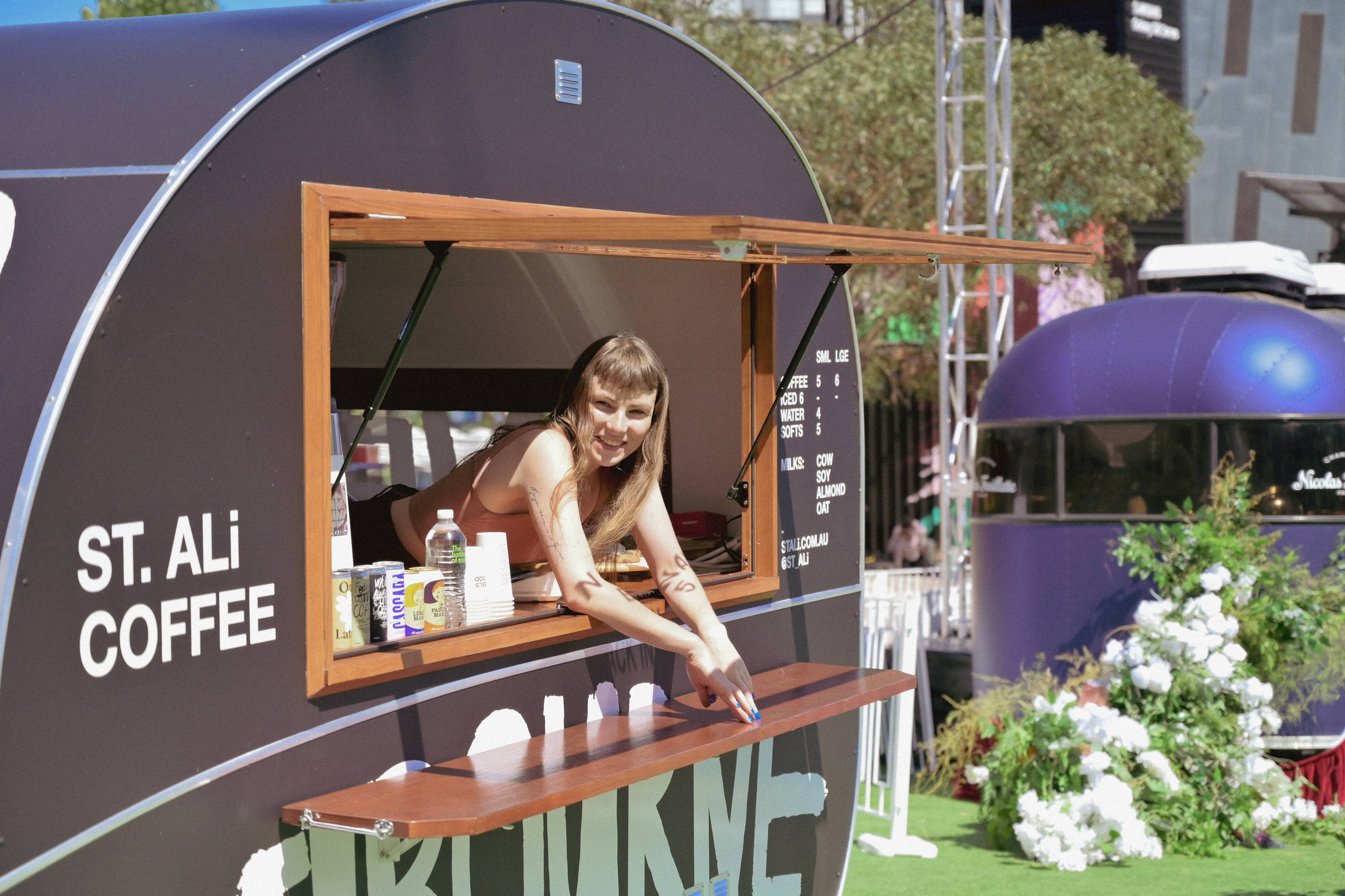 Smiling lady inside a coffee van stall
