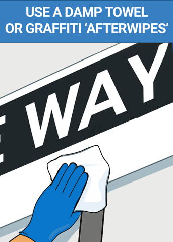 Wiping away residual graffiti from street sign after using Graffiti Safewipe