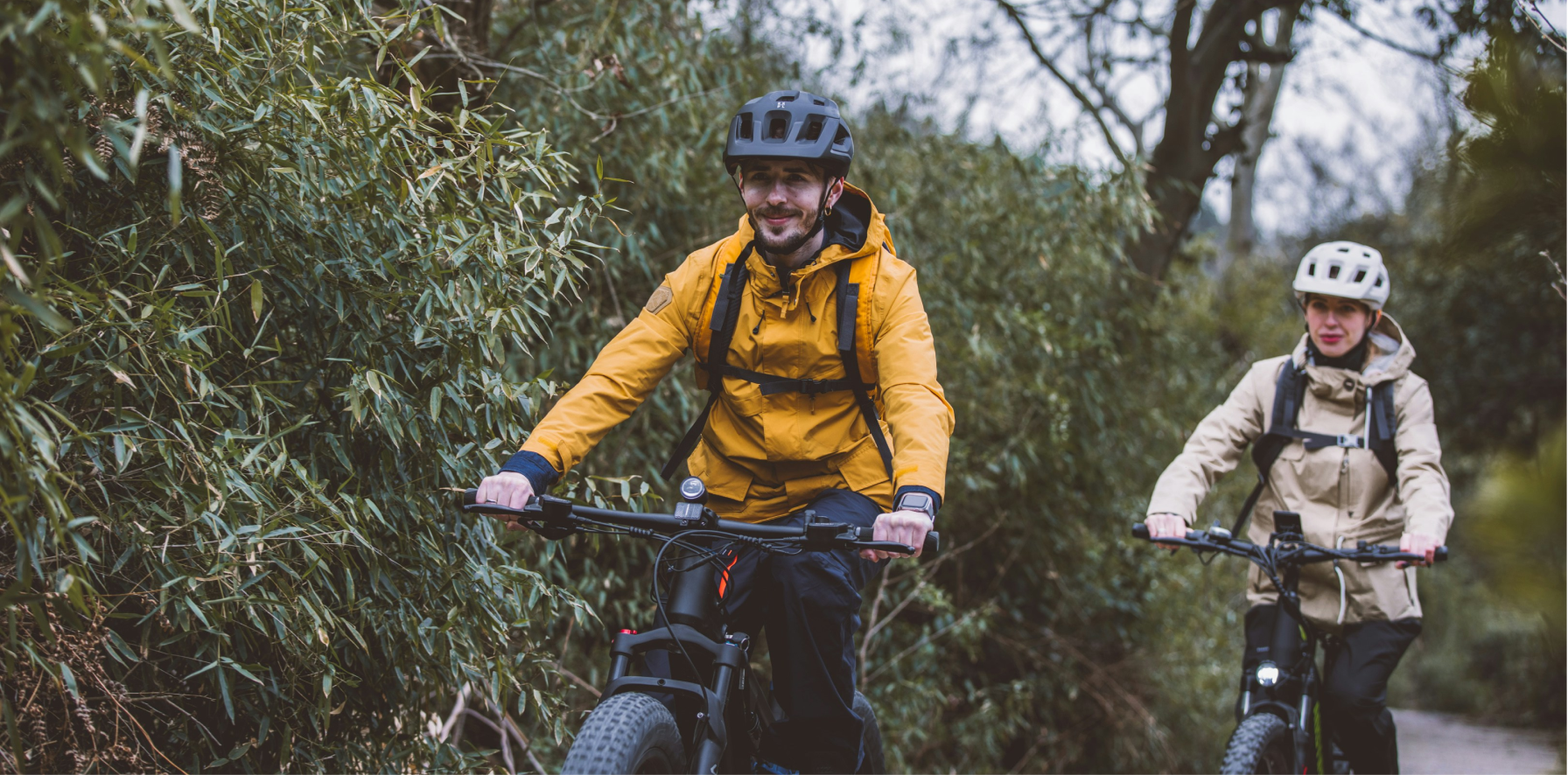 un hombre y una mujer paseando en bicicleta de montaña MTB