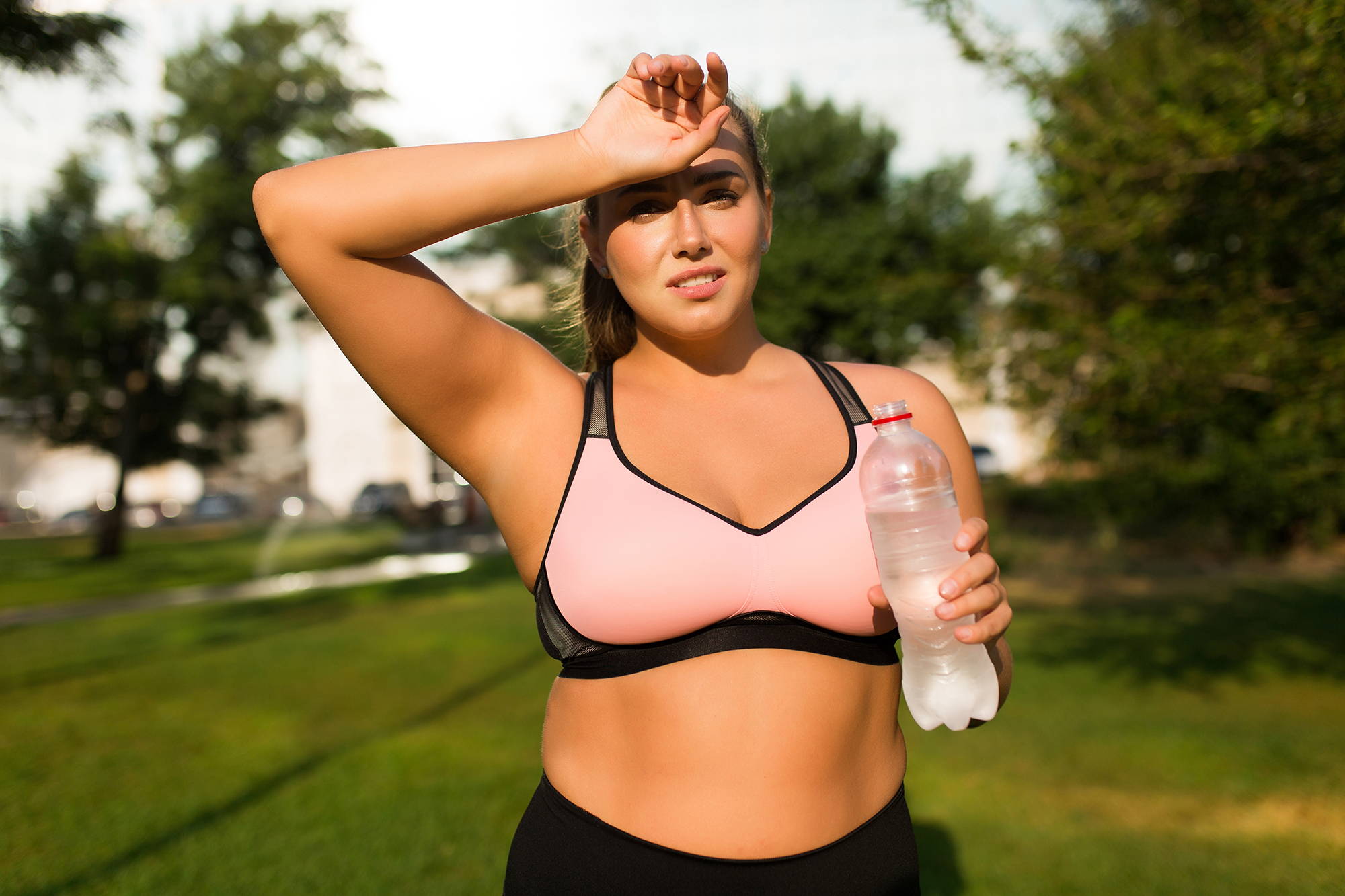 Woman in park exercising with water bottle