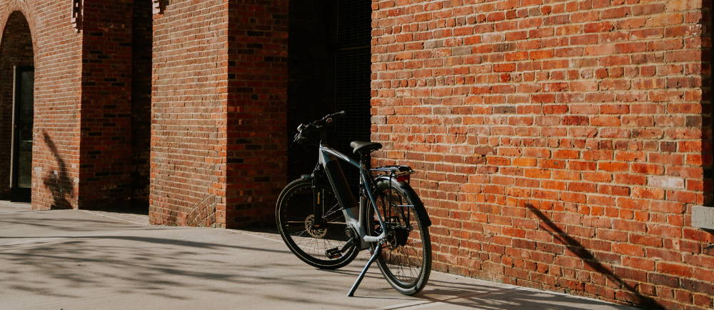 a Gazelle Ultimate C380+ electric city bike in front of a brick wall