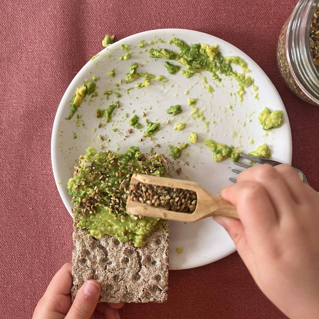 Un petit garçon utilise des couverts enfant pour dresser le couvert