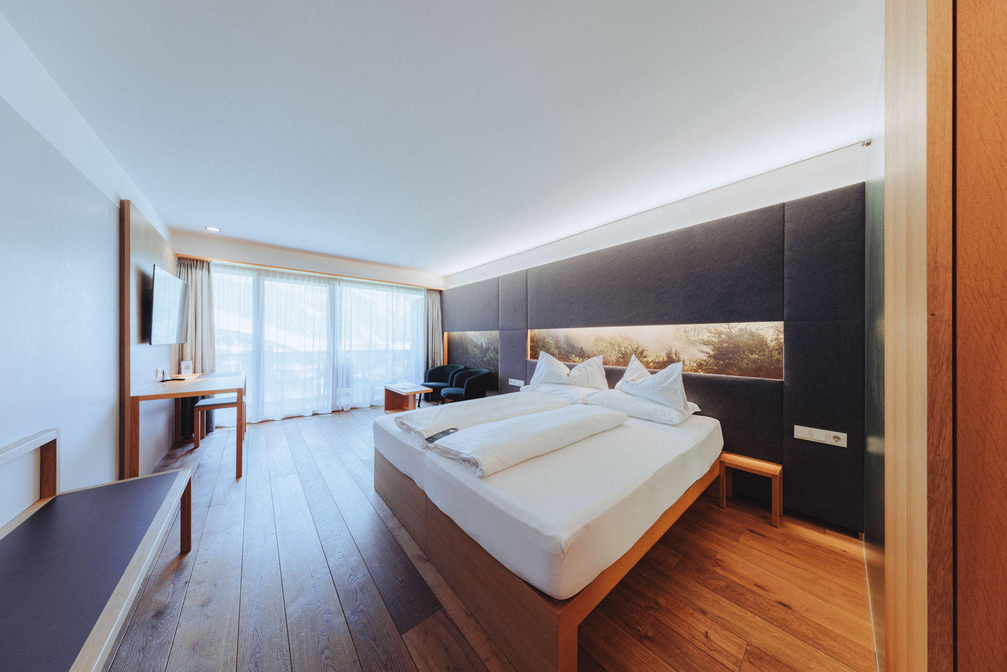 Barrierefreies Zimmer Hangspitze im Hotel Sonne Mellau mit Doppelbett und modernem Wohnbereich