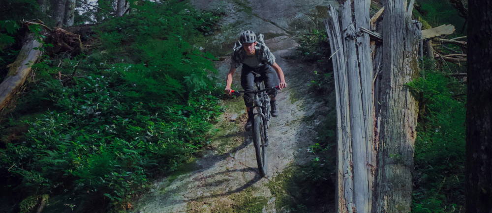 a man descending a mountain trail on a mountain bike