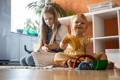 Sisters having fun playing with a Montessori Rainbow toy in their playroom.