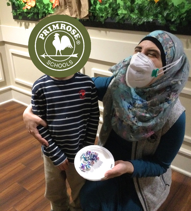 a student giving our director, Ms. Ayah, a handmade clay creation for world kindness day