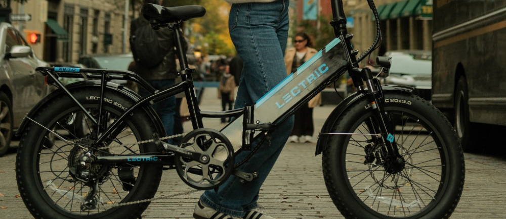 a woman standing next to a Lectric folding electic bike