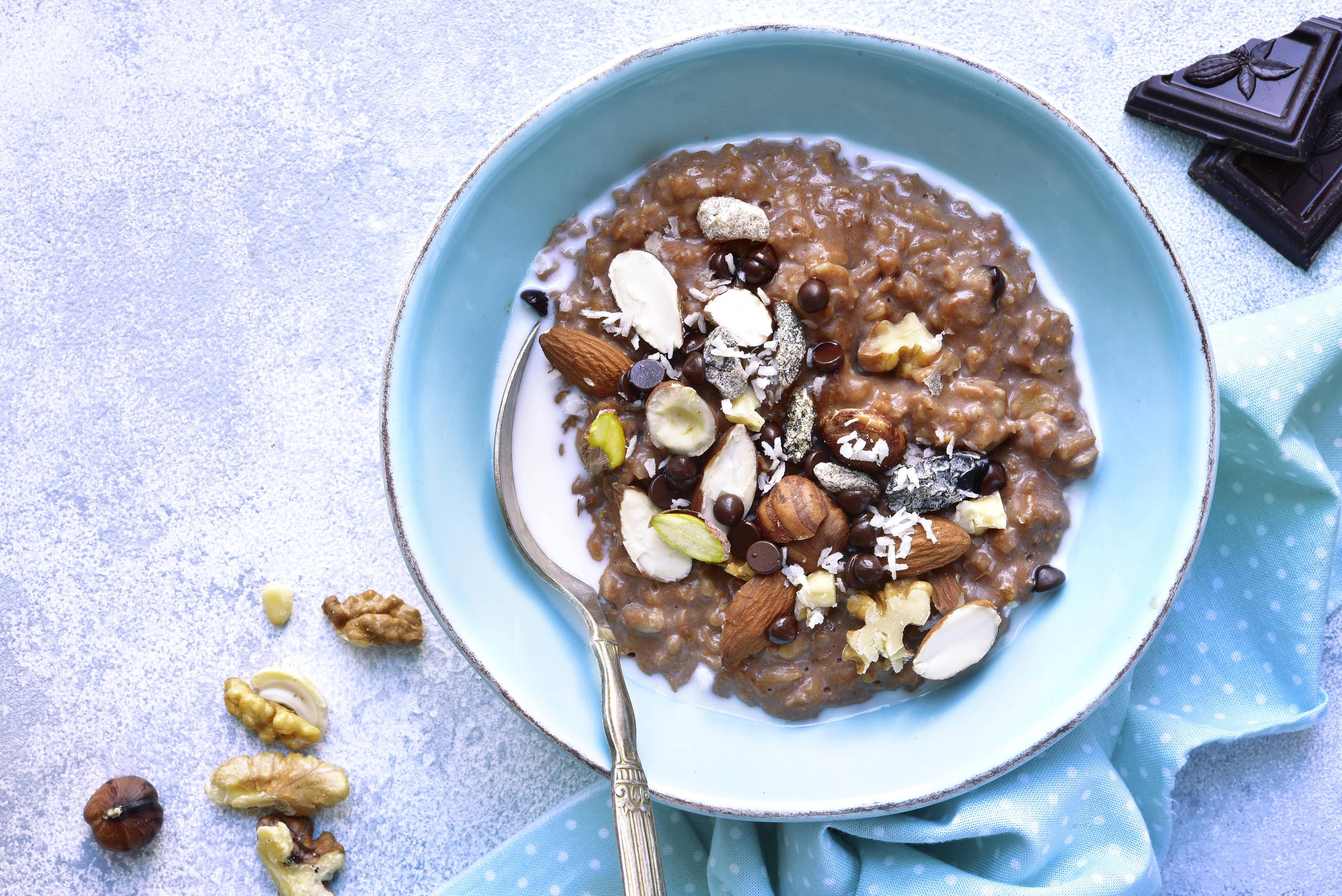 Vegan chocolate overnight oats with almonds and hazelnuts in a blue bowl