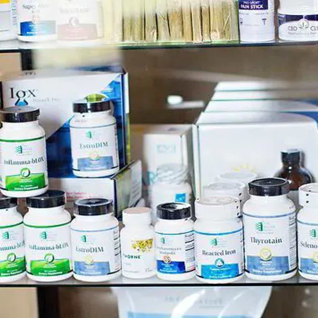 Assorted pharmaceutical bottles and containers labeled with brand names on store shelves.