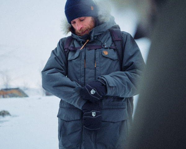 Man wearing recycled, waterproof and insulated jacket in the snow from sustainable outdoor brand Fjällräven