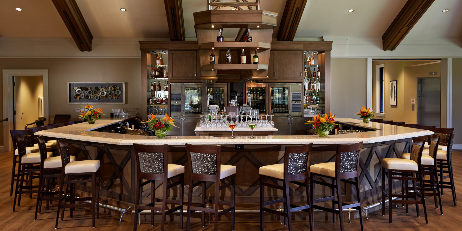bar featuring a kitchen breakfast bar, wood beam ceiling, light hardwood flooring, light countertops, and dark brown cabinets