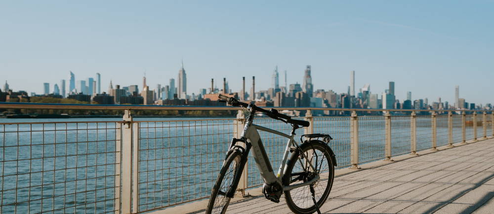 a gazelle electric city bike by the hudson river with new york city in the background