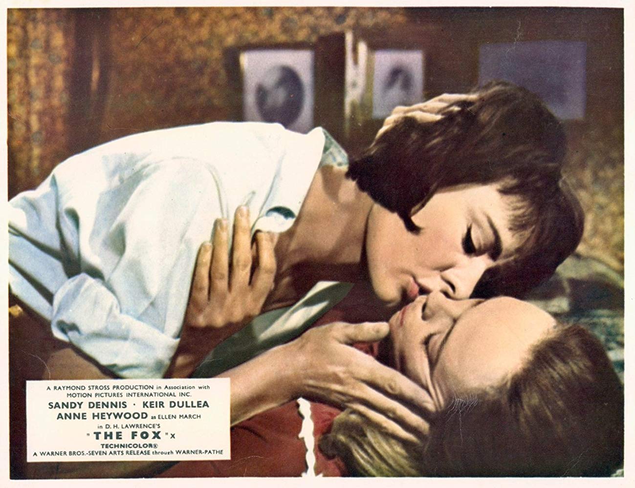 Image of the two women of The Fox kissing each other in a living room.