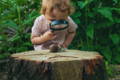 Baby putting a decoration on a birthday cake.