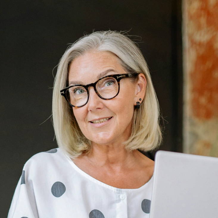 woman with blonde, grey bob hairstyle wearing glasses